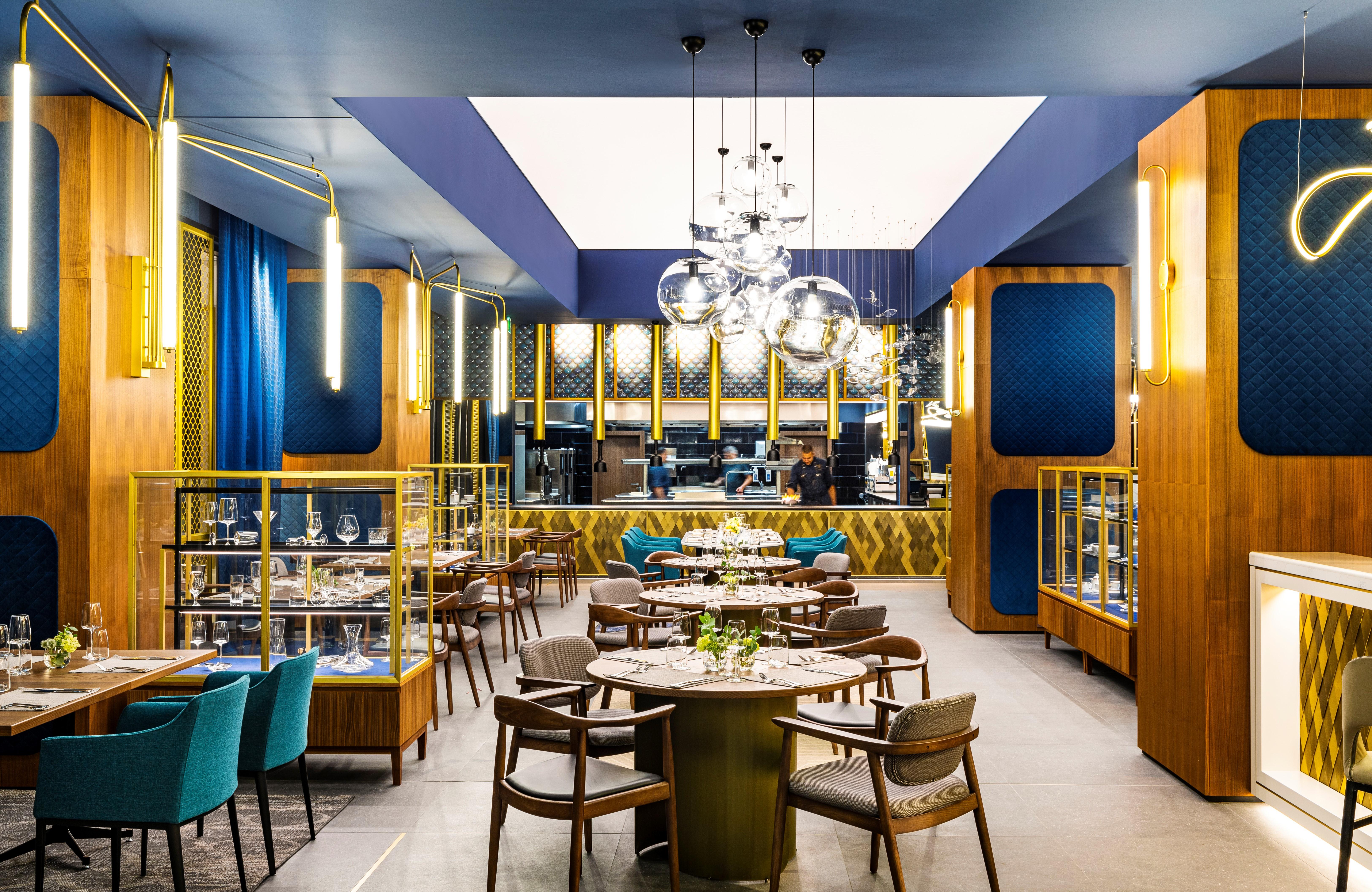 Grand Hotel Millennium Sofia Bagian luar foto The photo depicts a modern restaurant interior characterized by sleek and elegant design elements. The space features wooden accents, with warm tones creating an inviting atmosphere. 

Tables are arranged centrally, surrounded by comfortable upholste
